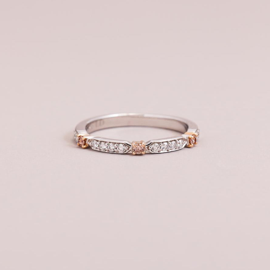 A slim 18ct rose and white gold wedding ring featuring pink and white diamonds, with the ring's band visible.