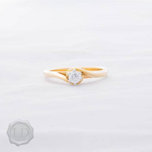 Yellow gold round brilliant cut solitaire engagement ring with hug twist